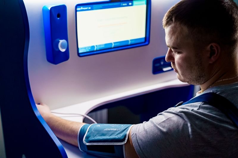 Man using a digital blood pressure monitor at home